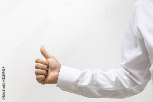 Closeup of businessman hand wearing white shirt show thumb up with copy space.