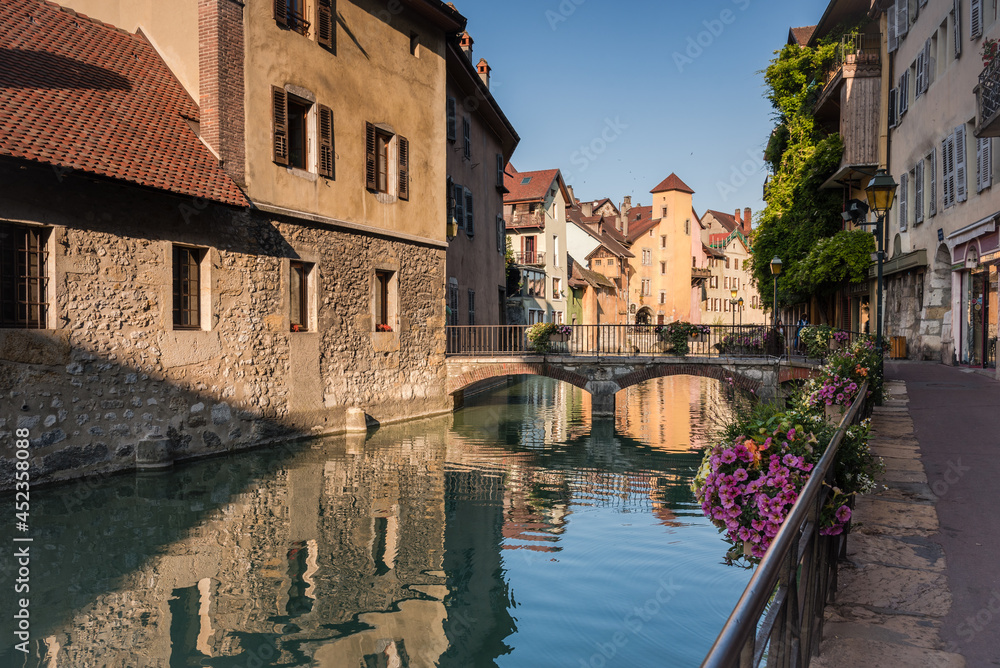 Medieval old town streets of Annecy and the reflection of the buildings in the water of the canal, France