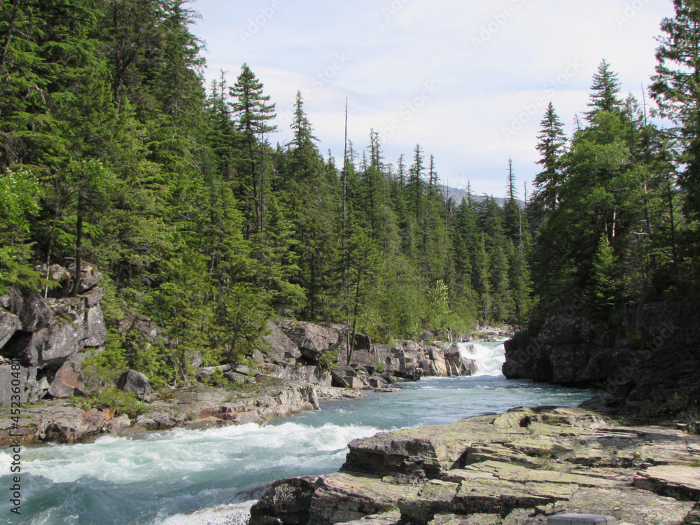 Fast flowing pristine river in Glacier National Park, Montana Fast flowing pristine river in Glacier National Park, Montana