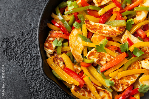 Tasty Halloumi cheese Fajitas with mix pepper in iron cast pan. Healthy food.