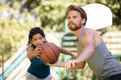 beautiful couple in love flirting and playing basketball