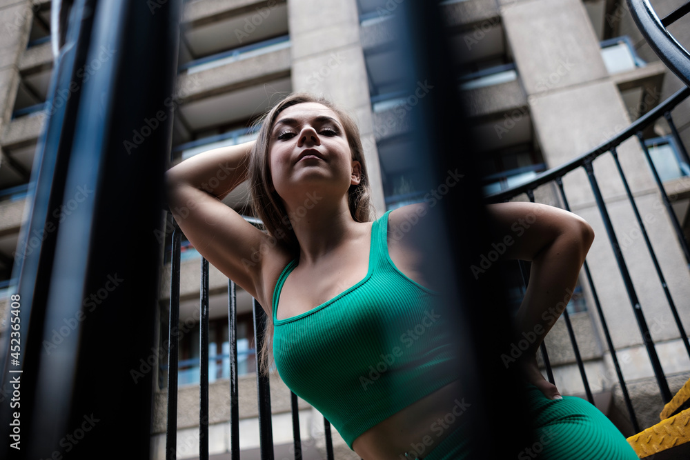 Young fitness woman posing through banister. Young fitness woman posing through banister.