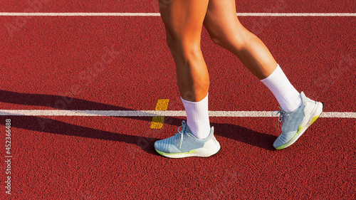 female legs in sports sneakers step on the stadium running track. sports training and exercise, healthy lifestyle. © x.marynka