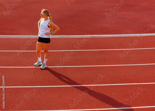 young woman in sports uniform stands at the stadium. sport exercise. healthy lifestyle