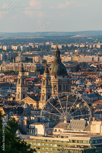 Budapest cityscape in golden hour. Included the budapest eye giant ferris wheel and a famous hotel in Danube river bank.