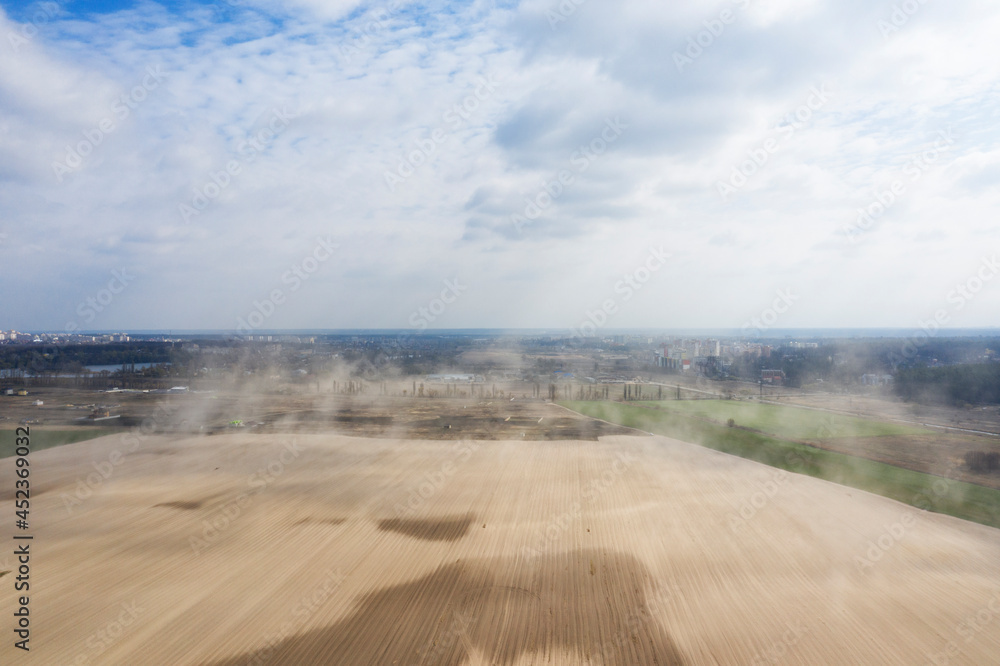Dust storm on an agricultural field. Drone view Dust storm on an agricultural field. Drone view