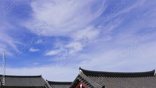 Peaceful clouds passing over the roof of traditional Korean hanok architecture
