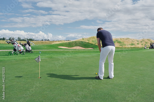a man plays golf on a green background