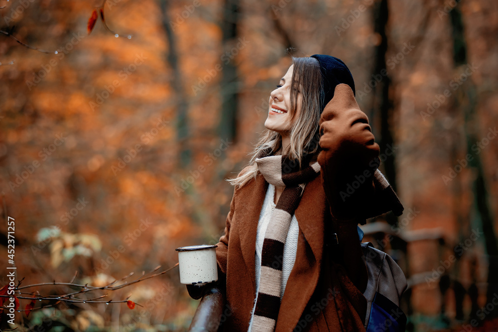 Young woman with cup of coffee in an autumn season park Young woman with cup of coffee in an autumn season park