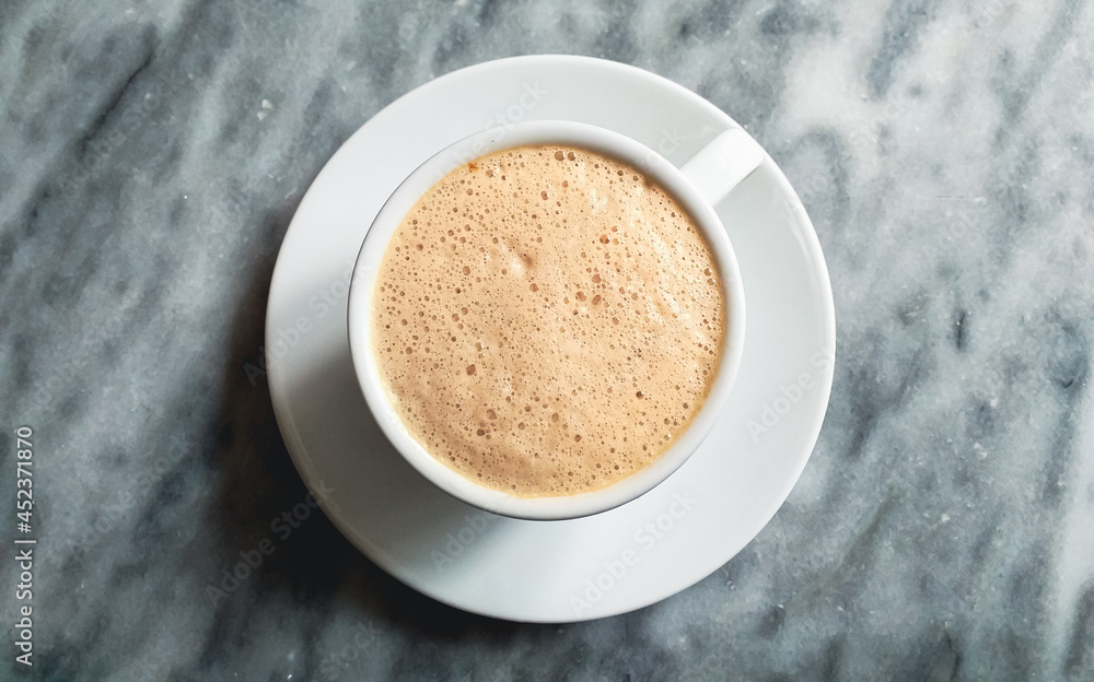 Fototapeta premium full cup of cappuccino or coffee close up on grey marble stone background