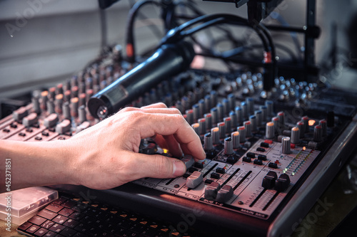 DJ's hand touching the audio control panel © phantom1311