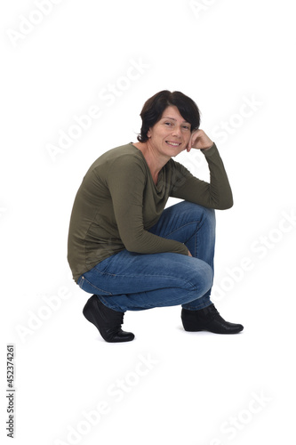 side view of a woman crouching and hand on face on white background