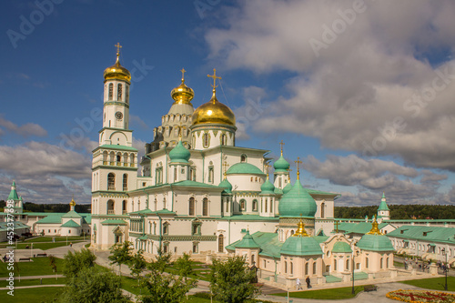 the white-stone Cathedral of the Resurrection of Christ in the New Jerusalem Monastery on a sunny summer day against a blue cloudy sky in Istra Moscow Region