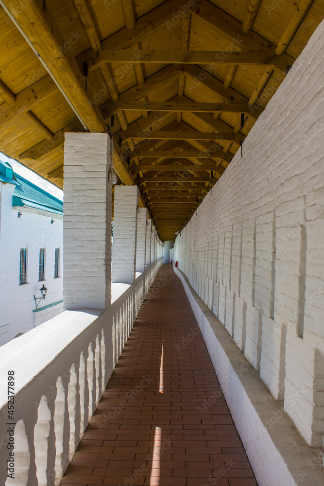 Fototapeta premium Istra, Moscow Region, Russia - August, 22, 2021: a long gallery on the white stone fortress wall of the monastery in New Jerusalem