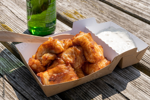 Deep fried cod fish in pieces served outdoor with tartar sauce photo