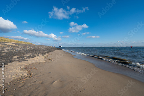 View on white sandy beach, dunes and water of North sea between Vlissingen en Domburg, Zeeland, Netherlands