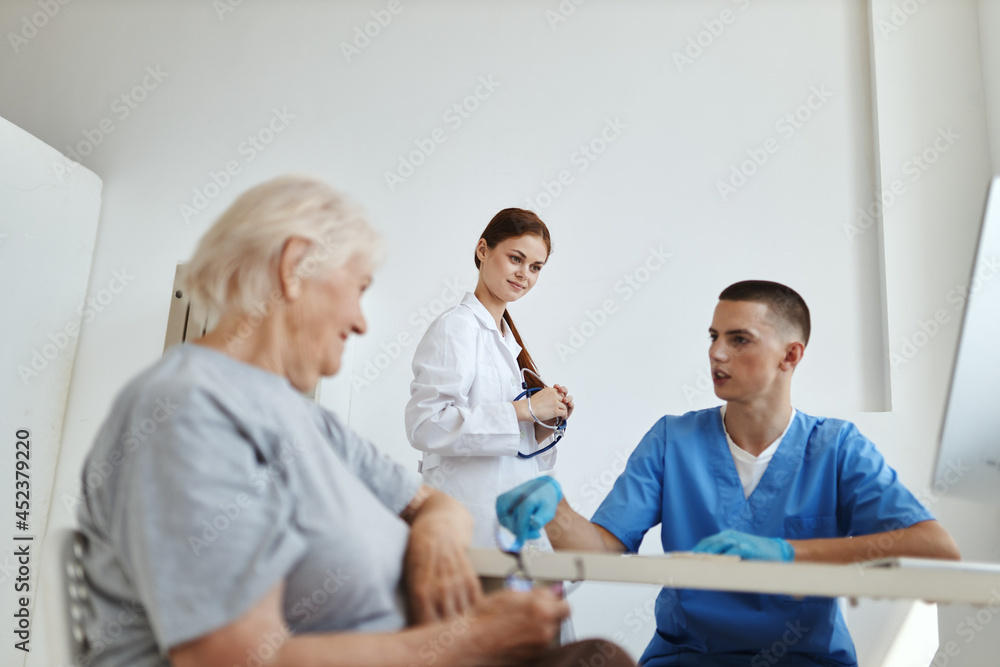 an elderly woman communicates with a nurse in the doctor's office diagnostics treatment