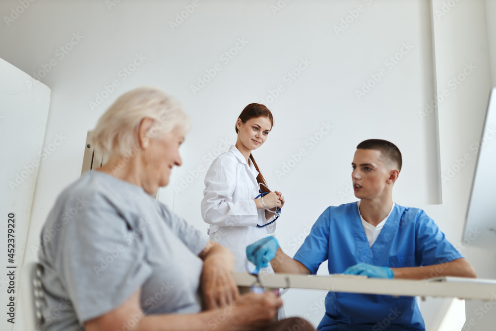 an elderly woman communicates with a nurse in the doctor's office diagnostics treatment an elderly woman communicates with a nurse in the doctor's office diagnostics treatment