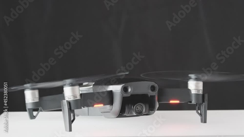 Drone quadcopter engine initiation and rotation diagonal view, futuristic gadget and electronics, professional tool for video and photo 60 fps 4K