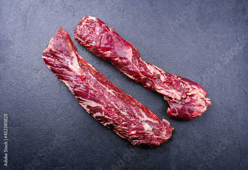 Raw wagyu onglet beef steak offered as top view on a black board photo