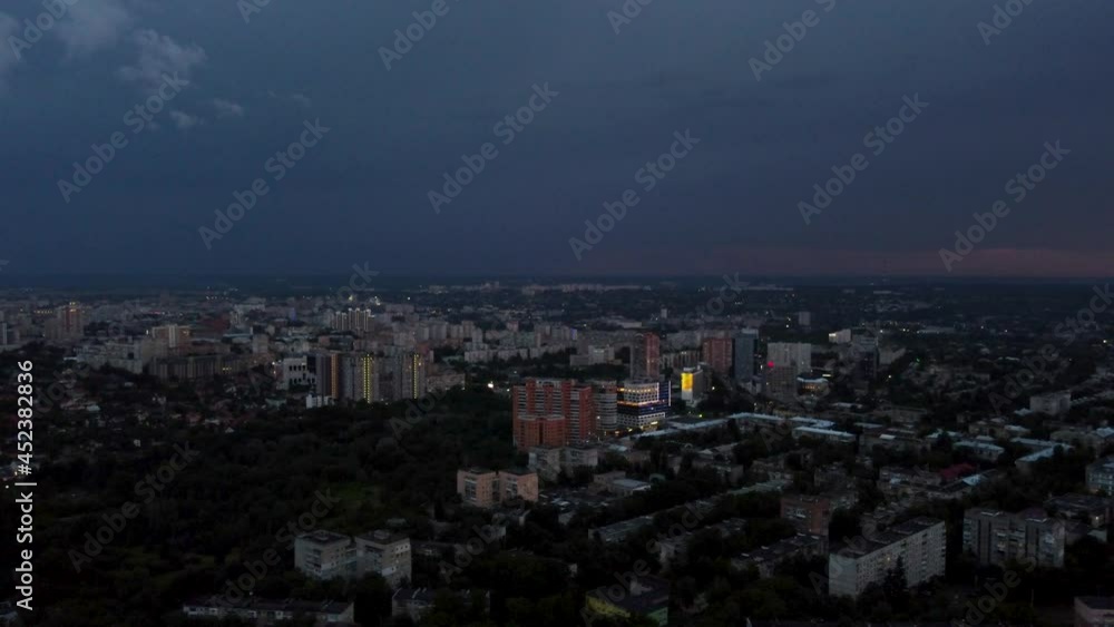Aerial evening left to right panoramic view on city with dramatic heavy sunset sky with clouds. Evening flight above city streets. Kharkiv, Ukraine city center park and residential district Aerial evening left to right panoramic view on city with dramatic heavy sunset sky with clouds. Evening flight above city streets. Kharkiv, Ukraine city center park and residential district