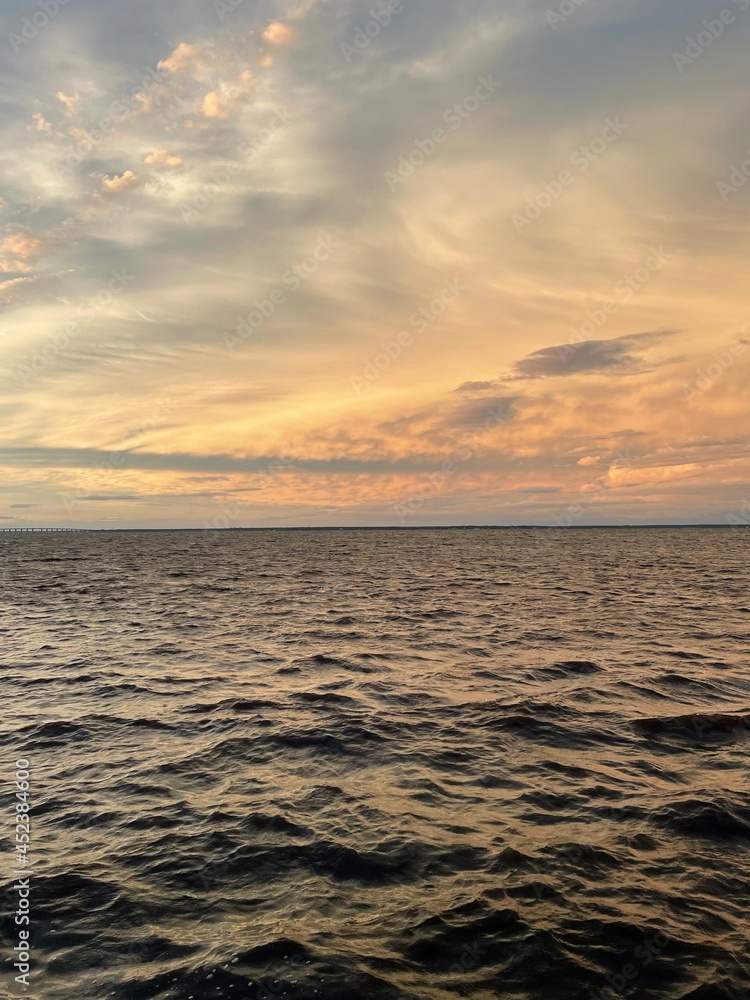 dramatic sunset clouds over bay water