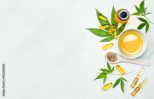 Obraz na plátně cbd oil, capsules, leaves and seeds  cannabis on gray concrete table, concept of
