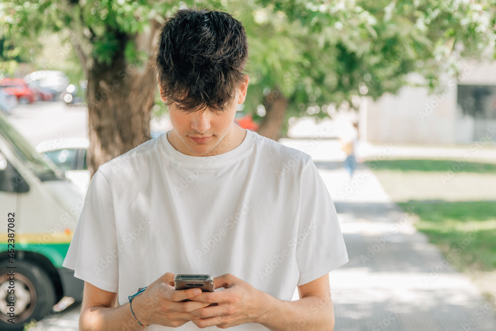 portrait of teenage boy with mobile phone in the street outdoors portrait of teenage boy with mobile phone in the street outdoors