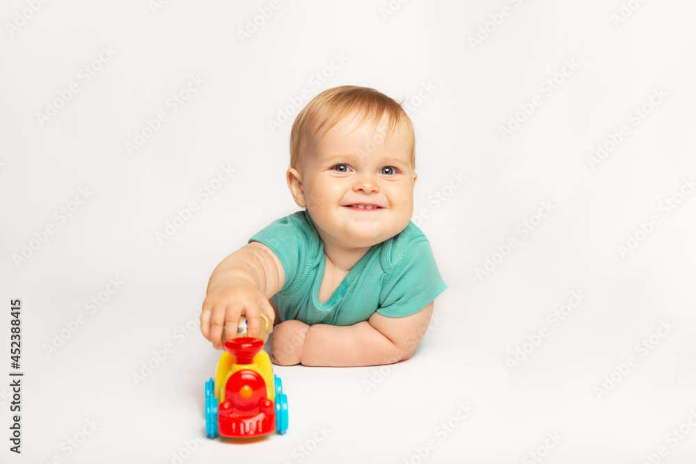 lovely cute baby boy rolling a toy car on the floor. child playing with toy train. childhood, kids and people concept lovely cute baby boy rolling a toy car on the floor. child playing with toy train. childhood, kids and people concept