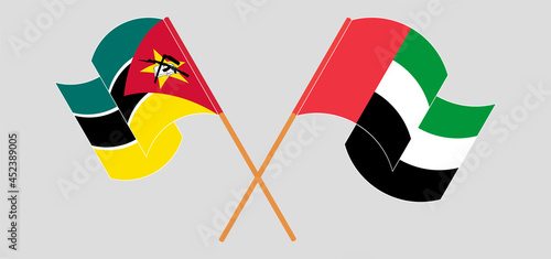 Crossed and waving flags of Mozambique and the United Arab Emirates