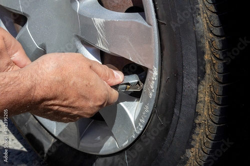 Man calibrating car tire. Selective focus. © Lais