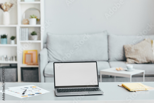 Minimal background image of home office workplace with laptop on desk in white airy interior, copy space