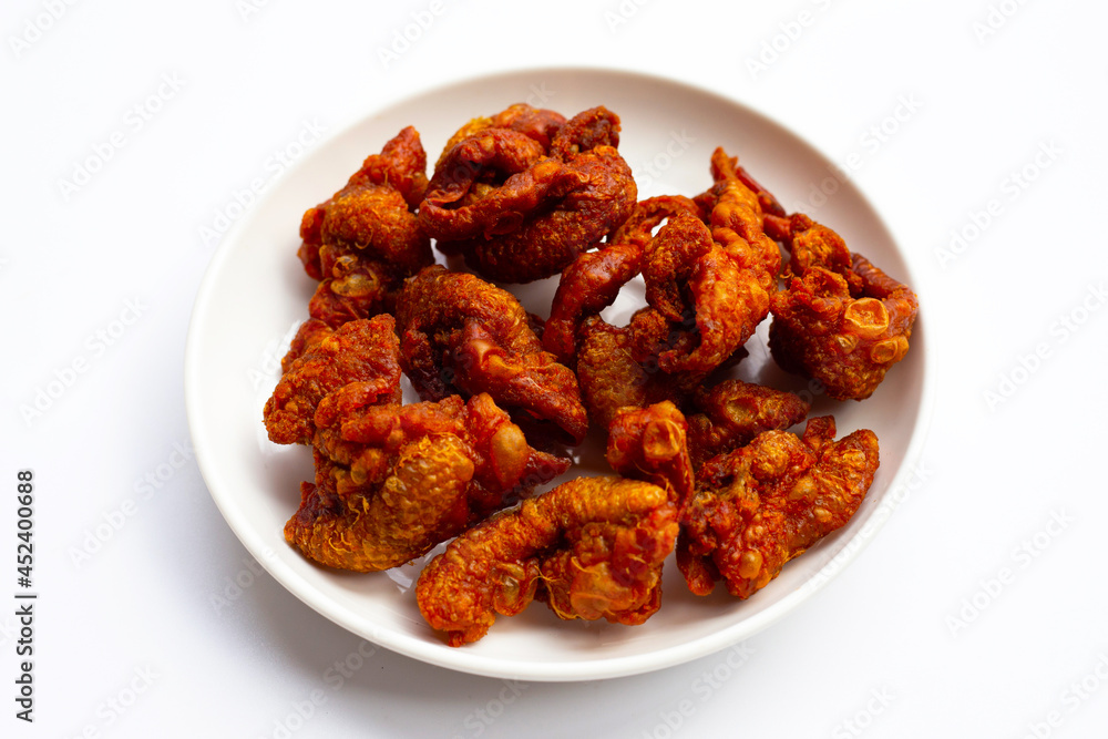 Chispy fried chicken skin in white plate on white background. Chispy fried chicken skin in white plate on white background.
