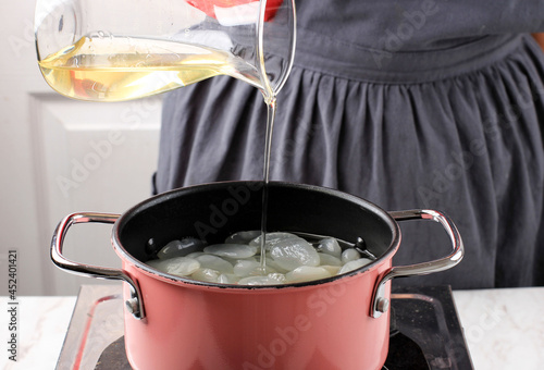 Pour Simple Syrup or Sugar Syrup or Liquid Sugar to the Pan, Process Making Manisan Kolang Kaling (Sugar Palm Fruit) for Ramadan or Ied Fitr photo