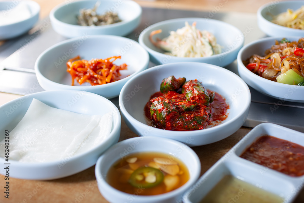 A view of several varieties of banchan, delicious side dishes that you eat with cooked meat slices in a Korean BBQ restaurant.