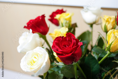 A closeup view of a bouquet of roses  featuring a red rose.