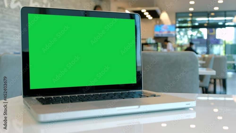 Chroma key green screen laptop computer set up for work on a cafe desk. Chroma key green screen laptop computer set up for work on a cafe desk.