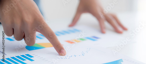 Hand of young business man pointing document data graph and chart paper, marketing and investment, report of statistics profit for financial, economic and growth of finance, management and planning.