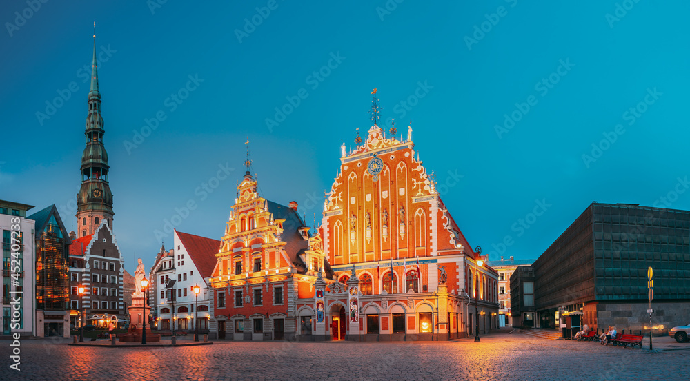 Riga, Latvia. Town Hall Square With St. Peter's Church, Schwabe House, House Of Blackheads. Famous Landmarks In Summer Evening Or Night At Blue Hour.