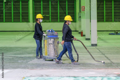 Construction workers are using industrial vacuum cleaner cleaning floor before epoxy primer Self-leveling method of epoxy floor finishing work