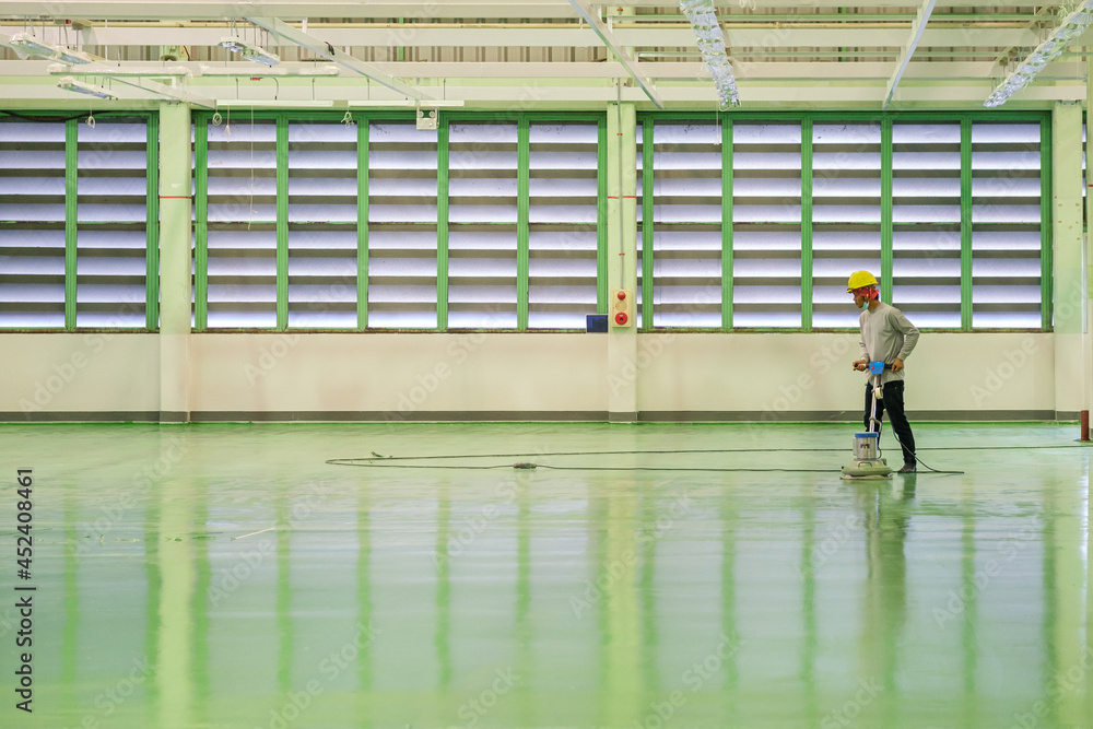 Construction worker using floor grinding machine polishing floor before
