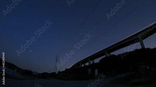 A timelapse form under a bridge. The stars are visible, the camera looks over a construction site,