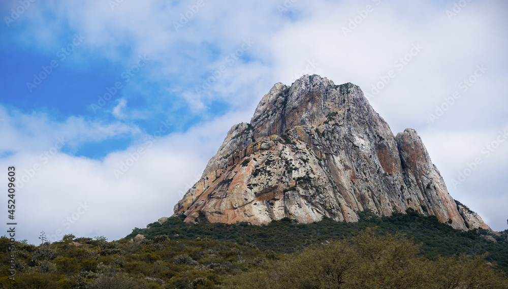 Peña de Bernal is the largest monolith in Mexico, beautiful landscape with a beautiful blue sky and white clouds.