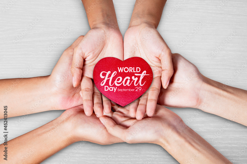 Three hands holding world heart day text