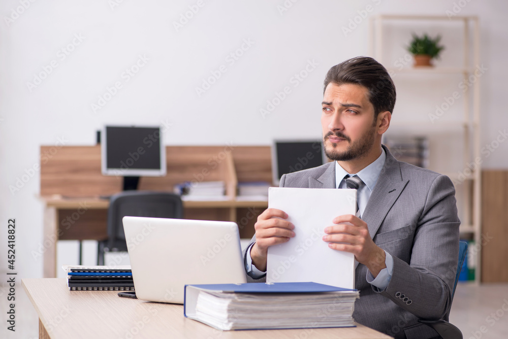 Young male employee working in the office Young male employee working in the office