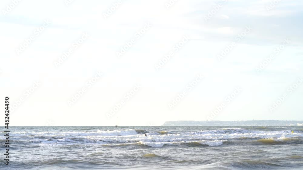 Sea waves breaking towards shore at Deauville - English Channel, surfers Sea waves breaking towards shore at Deauville - English Channel, surfers