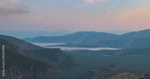 Day to night time lapse view looking across the Agioi Pantes towards the coastal town of Itea from Delphi, mainland Greece photo