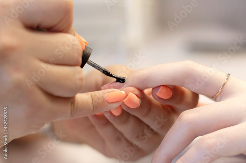 The process of manicure in a beauty salon by a specialist  with a copy of the space. Close-up