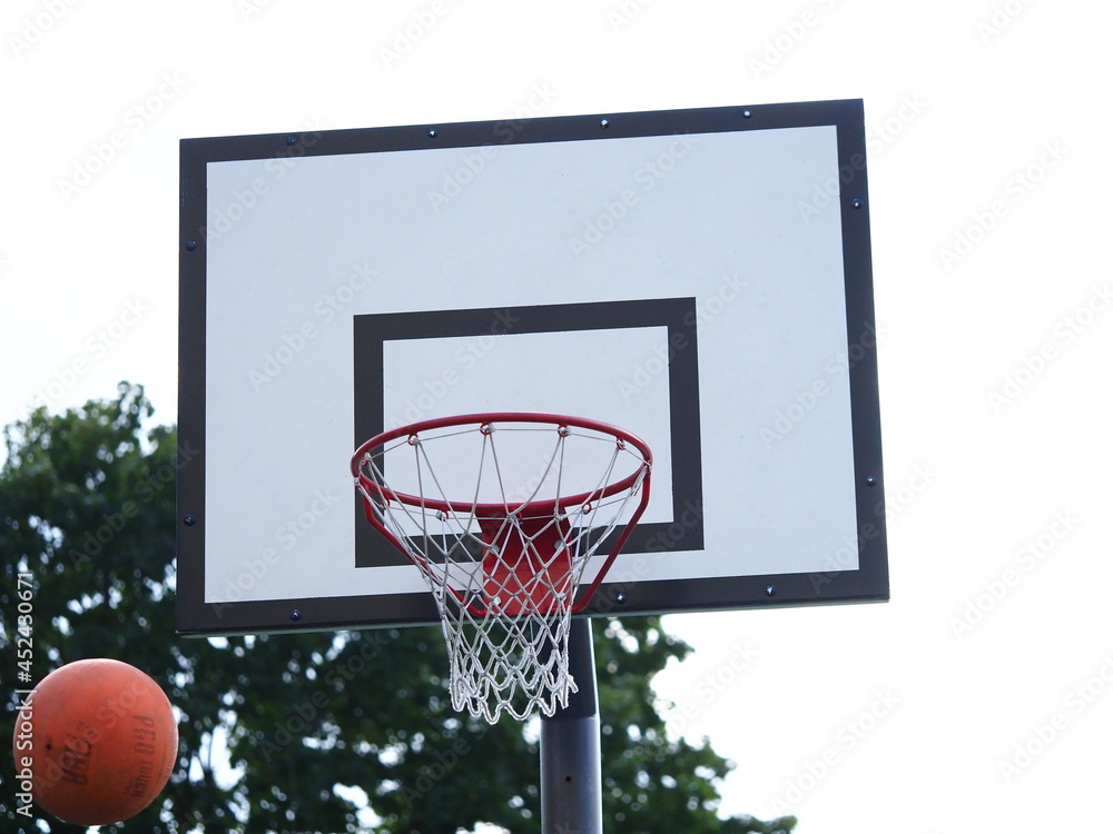 ball flies into the basketball hoop on the street during the game