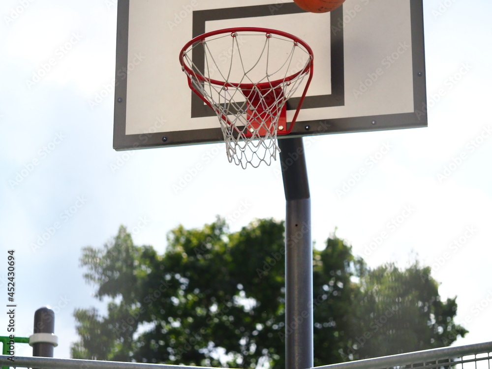 ball flies into the basketball hoop on the street during the game